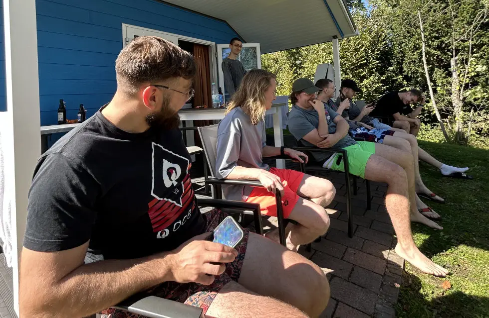 Team break in the sun outside the accommodation on the company trip
